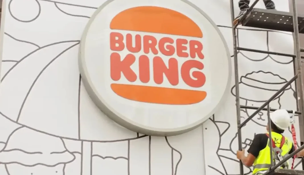 Fachada do Burger King sendo decorada com arte e elementos da campanha Bobbie Goods, com cores vibrantes e estilo ilustrativo.