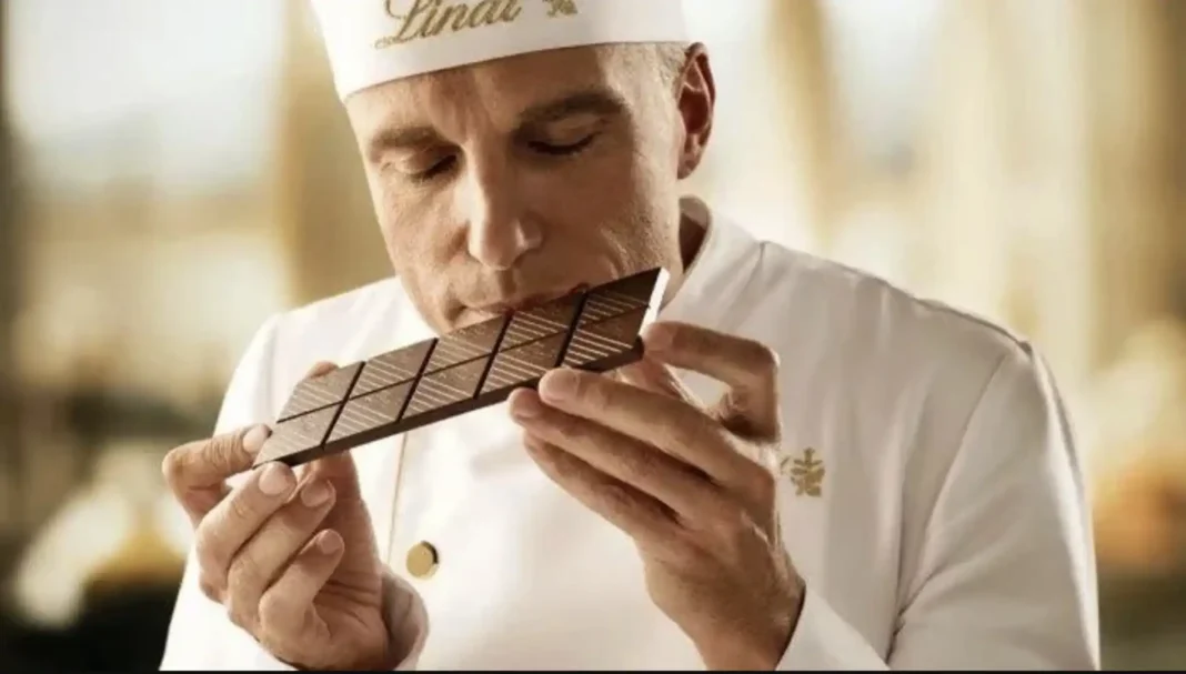 Mestre chocolatier Lindt cheirando uma barra de chocolate