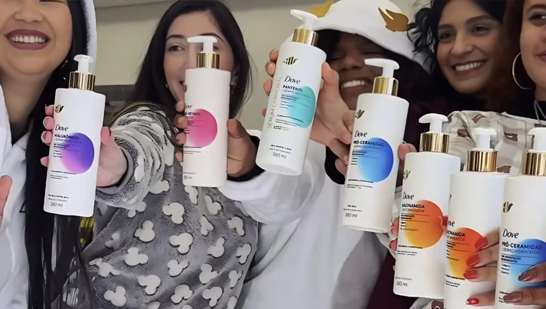 Cinco mulheres sorridentes seguram e exibem garrafas brancas de shampoo Dove, cada uma com um rótulo colorido diferente.