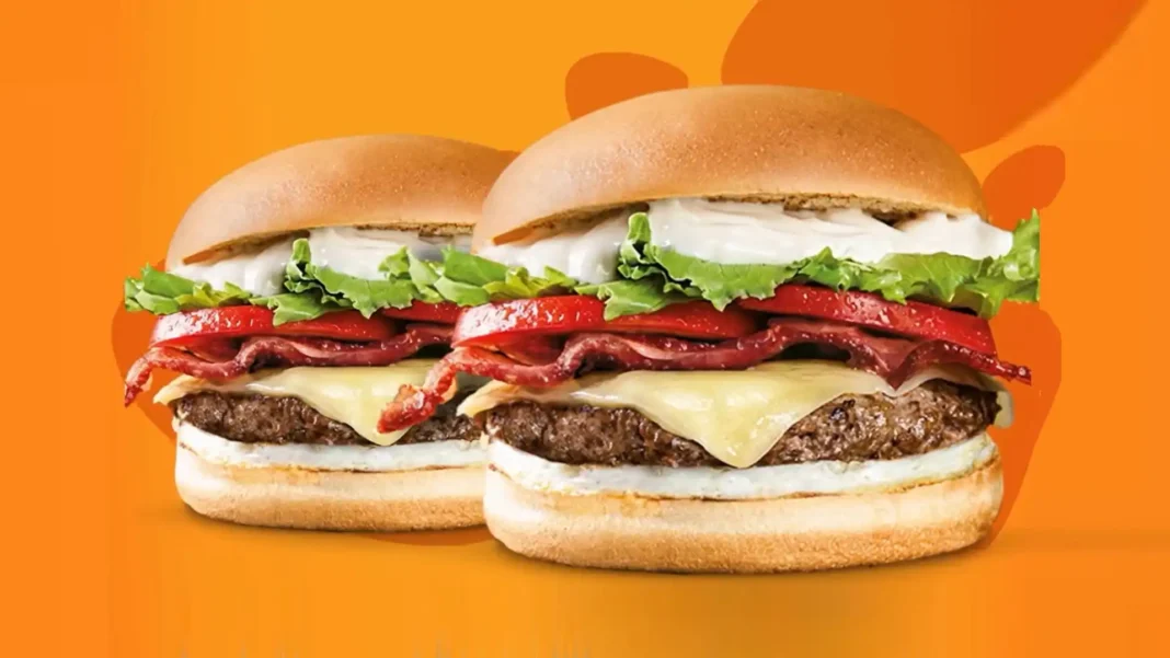 Imagem de promoção do Giraffas mostrando dois hambúrgueres gourmet em um fundo laranja