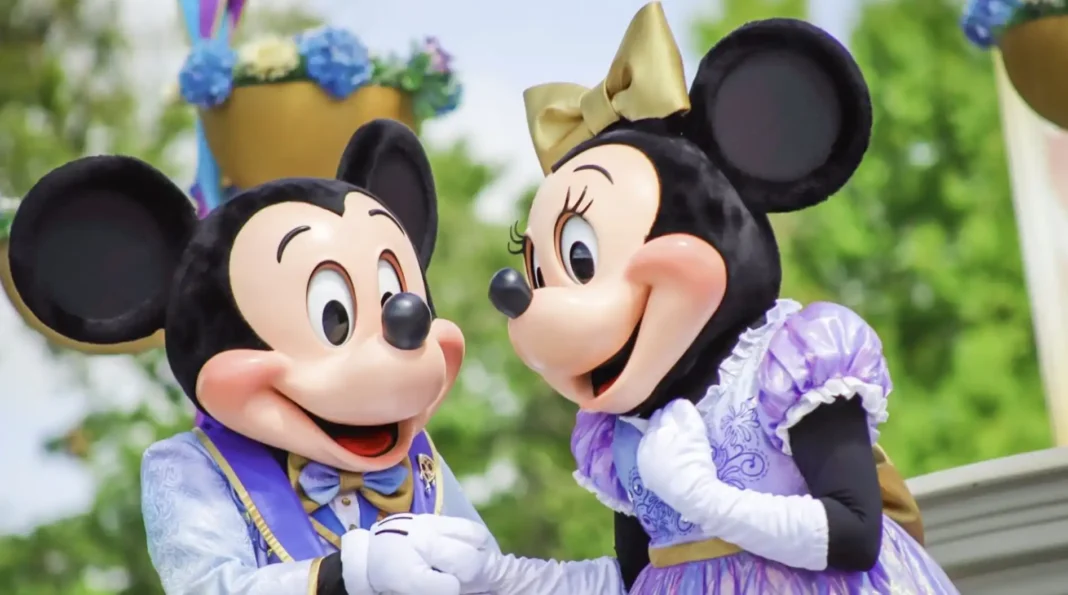 Mickey Mouse e Minnie Mouse em trajes festivos, Minnie em vestido roxo e dourado.