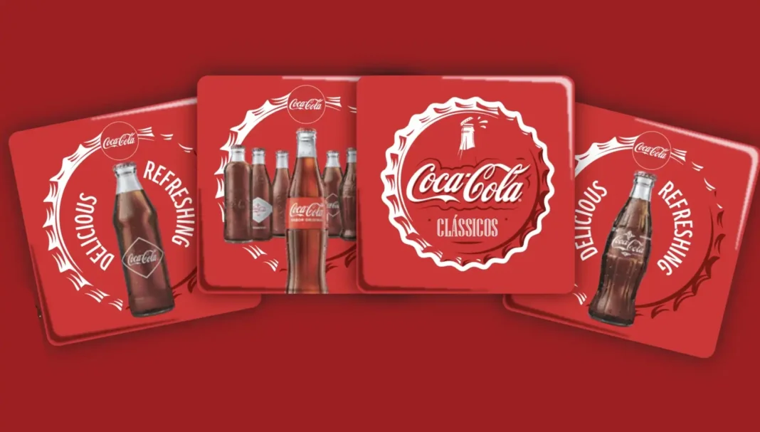 Quatro porta-copos vermelhos da Coca-Cola com designs diferentes, exibindo garrafas clássicas de Coca-Cola e slogans.
