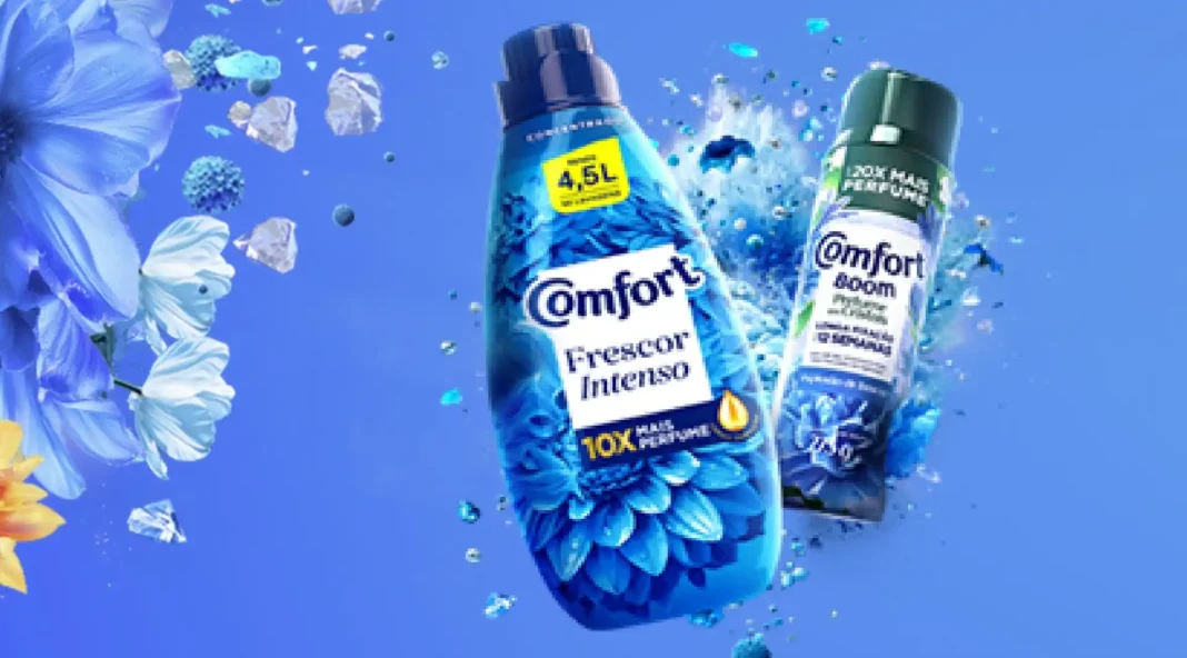Este banner de marketing vibrante apresenta dois produtos Comfort da Unilever em um fundo azul dinâmico com flores e gotas de água salpicadas.