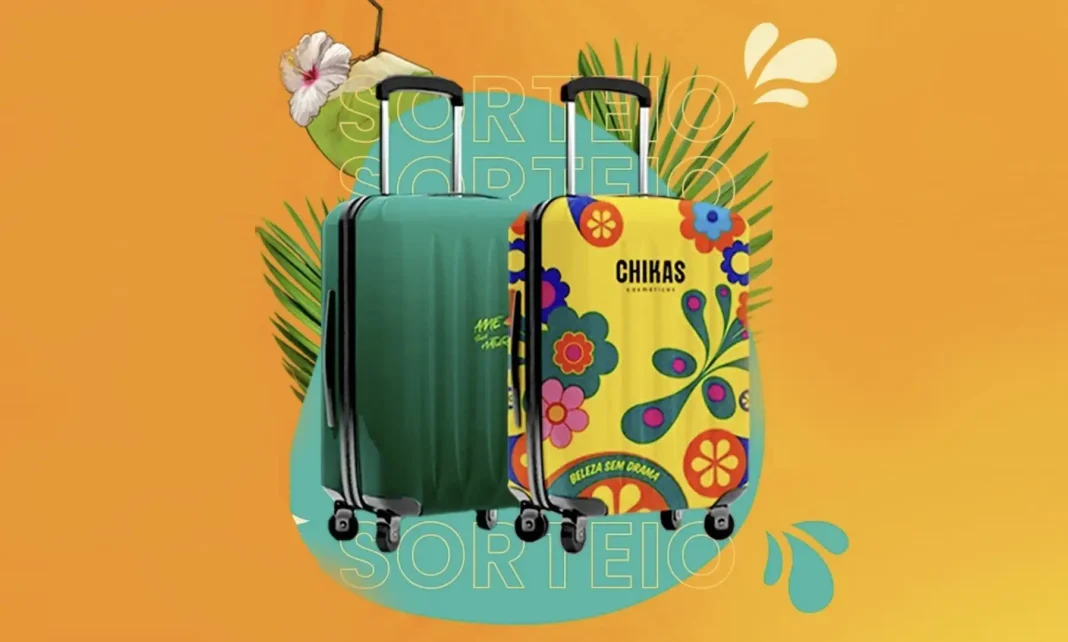 Duas malas de viagem, uma verde-escura e outra amarela com estampa floral colorida, posicionadas à frente de folhas de palmeira estilizadas. A mala verde tem um coco e uma flor de hibisco branca no topo. A mala amarela exibe os logotipos 