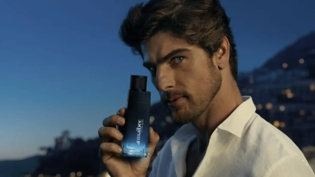 Homem de olhos azuis com perfume Malbec Ultra de O Boticário à noite.
