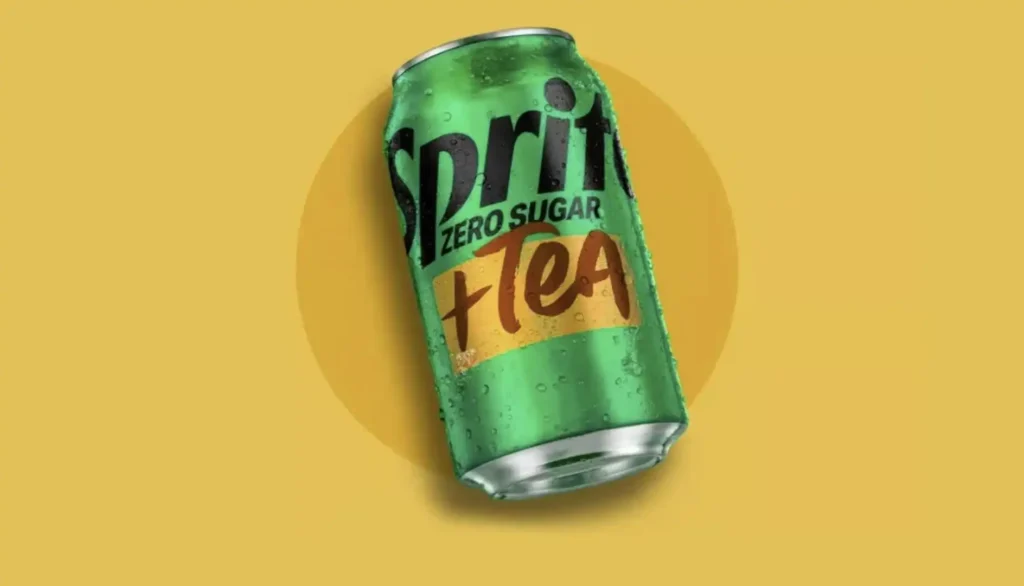 Texto Alternativo (Alt Text):Lata de Sprite Zero Sugar + Tea verde com gotas de condensação, inclinada sobre um fundo amarelo.