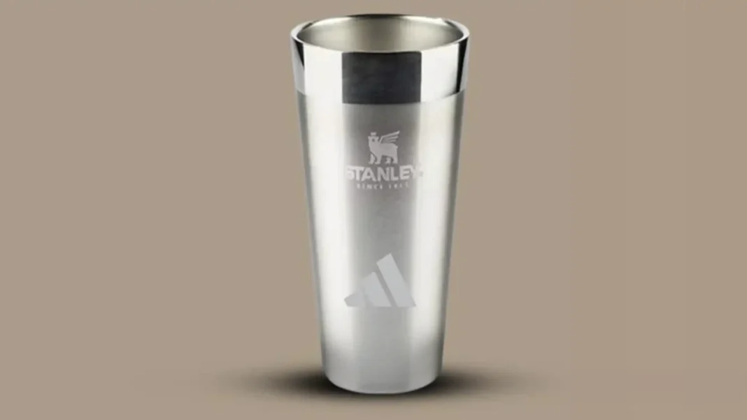 Copo térmico Stanley prateado com logotipo da Stanley e Adidas.