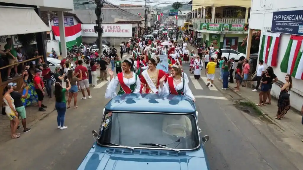 Desfile da Festa da Cappitella em Nova Venécia com carro alegórico e multidão.