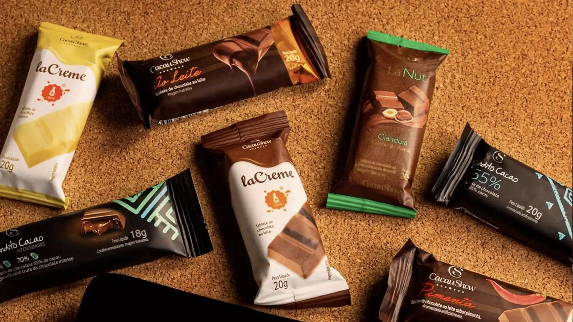 Exibição de vários chocolates da Cacau Show em uma superfície de cortiça.