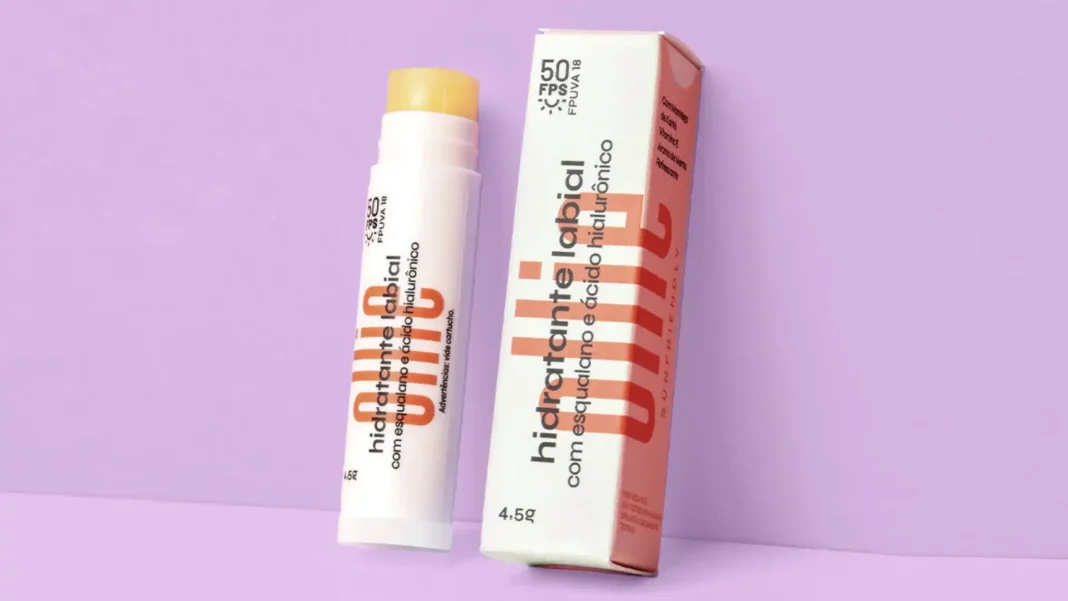 Um hidratante labial da marca Ollie com embalagem branca e detalhes em laranja. Ele tem proteção solar FPS 50.