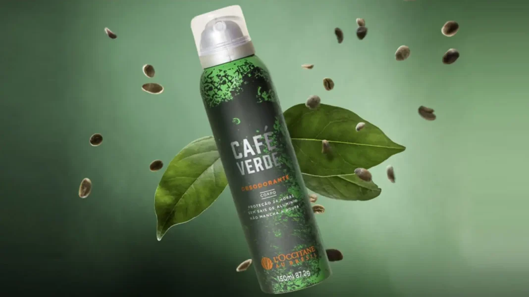 Lata de desodorante corporal em spray L'Occitane au Brésil Café Verde, cercada por grãos e folhas de café verde.
