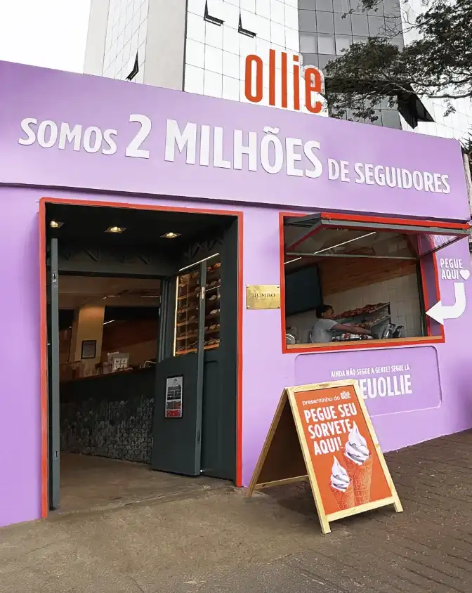 Uma loja pop-up roxa da marca Ollie com a frase "Somos 2 milhões de seguidores" em letras brancas.