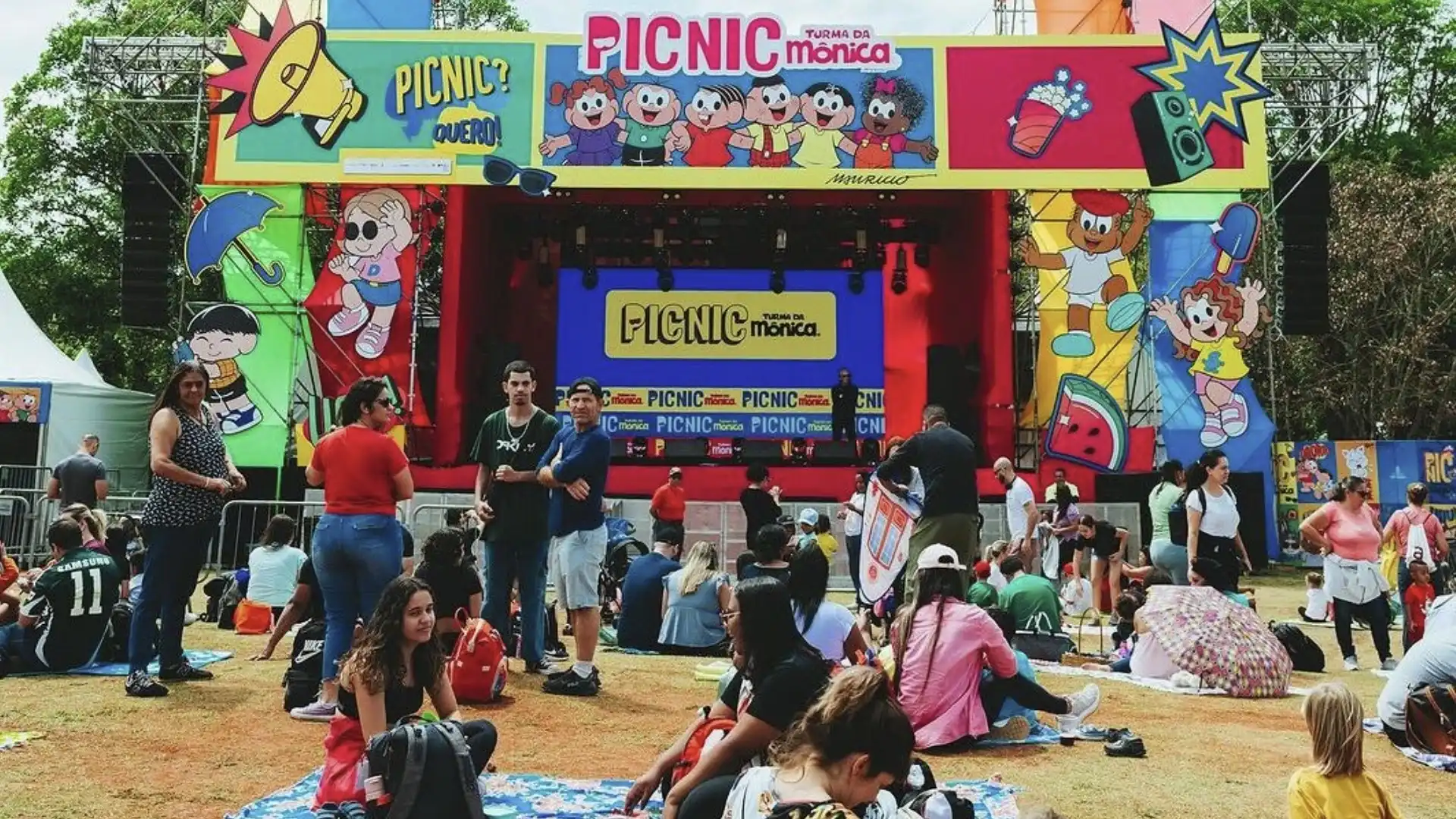 Público assiste a um evento da Turma da Mônica em um parque.