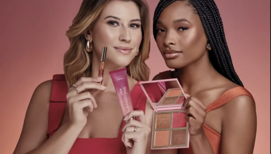 Uma modelo loira e uma modelo com tranças segurando produtos de maquiagem Eudora Niina Secrets.