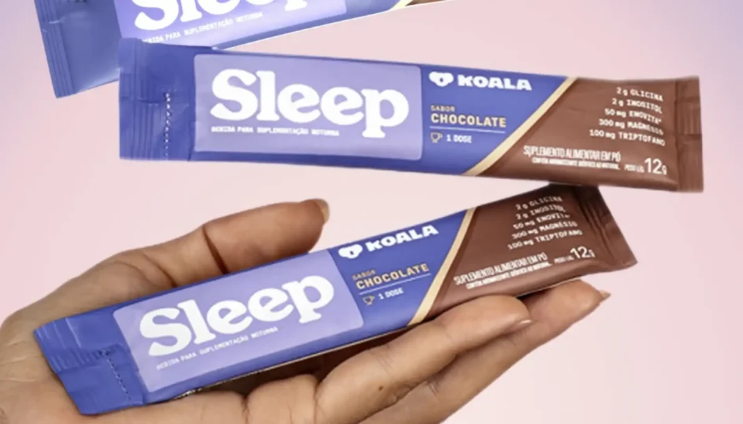 Pacotes da bebida em pó Sleep Koala de sabores morango e chocolate, exibidos contra um fundo gradiente roxo e rosa.