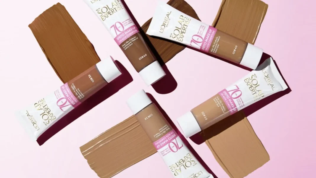 Protetor solar com cor L'Oréal Paris, mostrando quatro tubos de diferentes tons de base e suas respectivas amostras espalhadas.