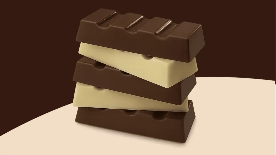 Um monte de barras de chocolate empilhadas, com duas de chocolate ao leite e duas de chocolate branco intercaladas, em um fundo marrom.