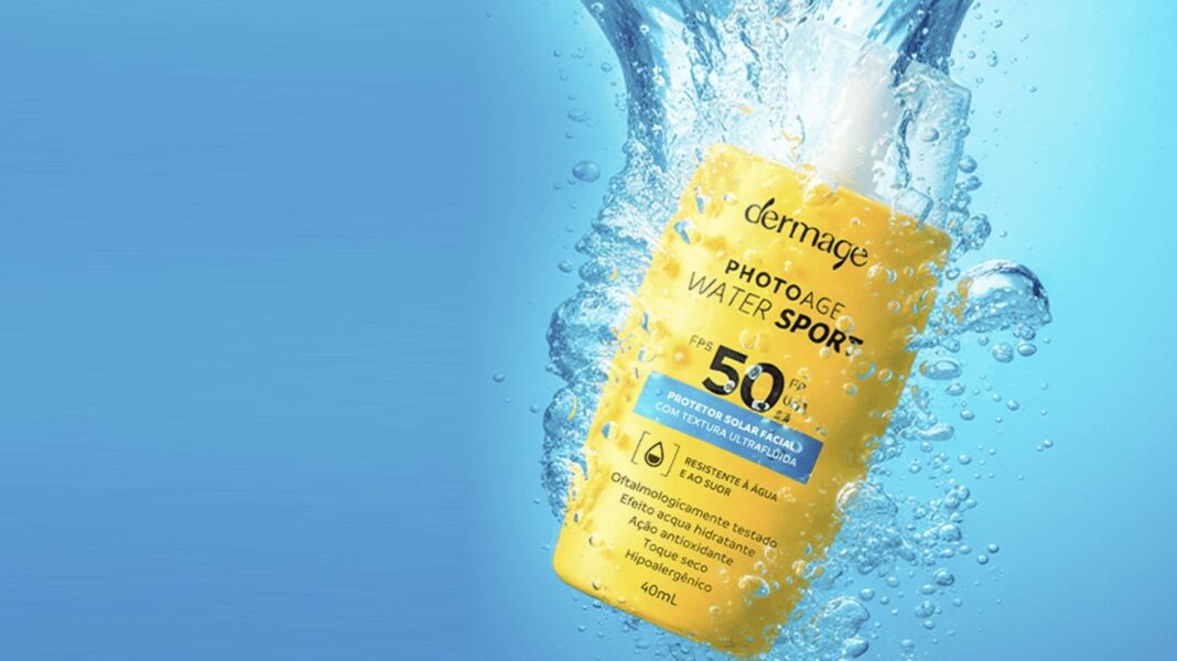 Dermage lança ação nacional com amostras gratuitas do protetor solar resistente à água Frasco amarelo de protetor solar Dermage Photoage Water Sport FPS 50 em meio a respingos d'água.