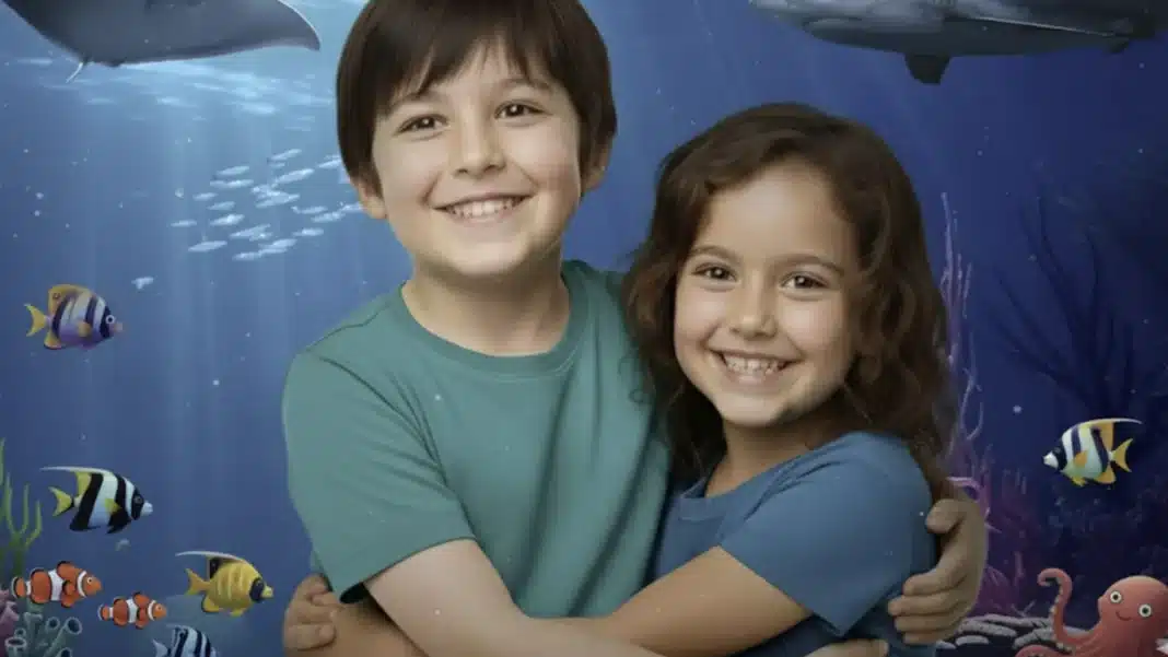 Duas crianças sorridentes abraçadas em um cenário aquático vibrante com peixes coloridos e vida marinha.