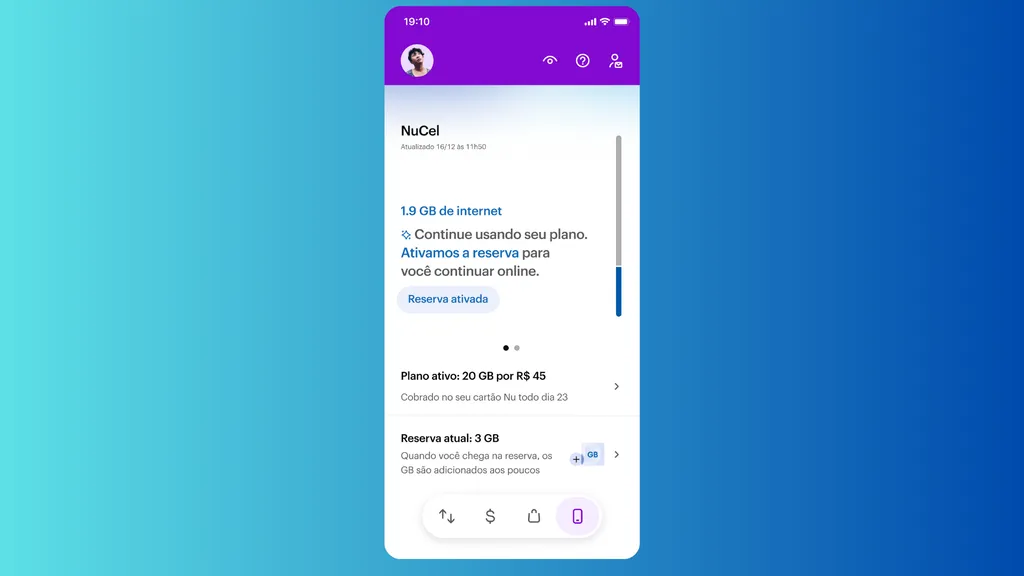 Um celular com o aplicativo do Nubank aberto, exibindo a tela inicial de autenticação, é segurado por uma mão. O logotipo da empresa também aparece em um notebook desfocado ao fundo.