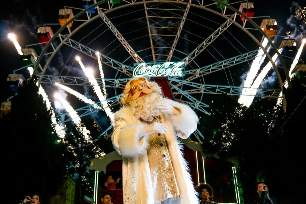 Papai Noel no palco em frente a uma roda-gigante iluminada com fogos de artifício no Hopi Hari.